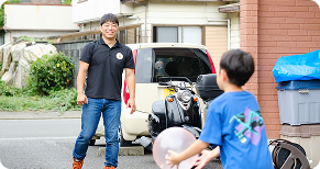 保育士が外で子供とサッカーをしているシーン